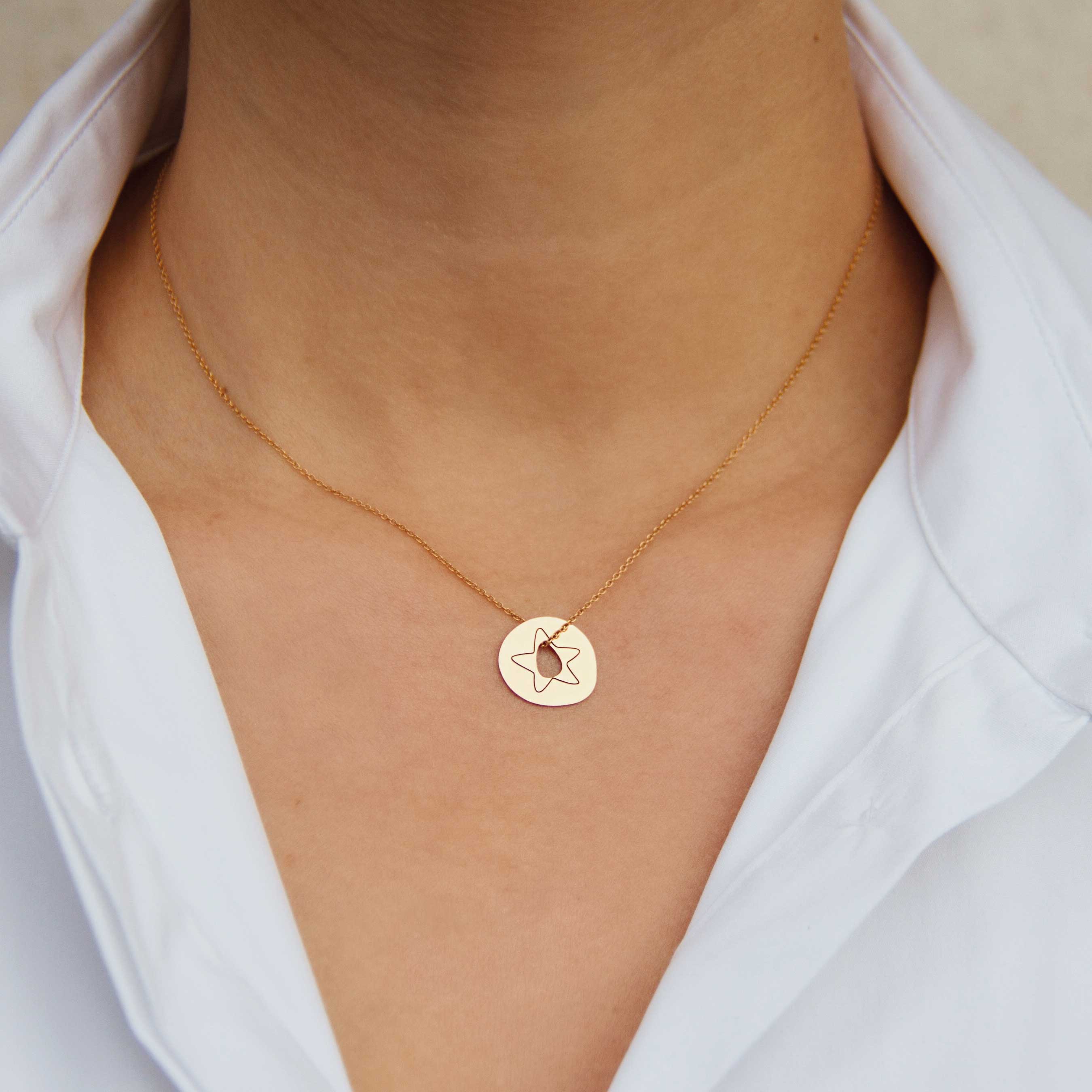 gold pendant with a star on a woman