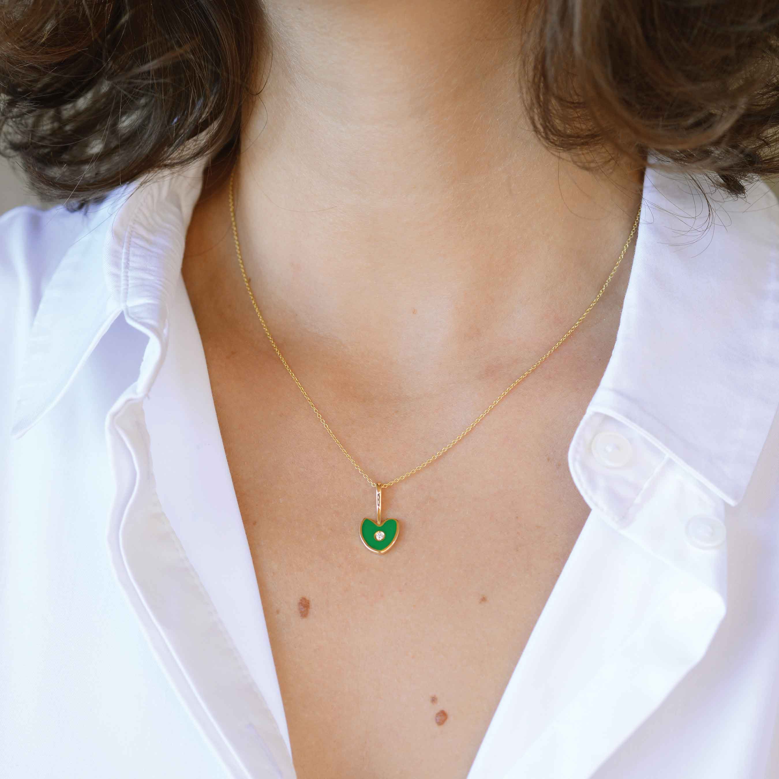 green gold heart with white diamond on a woman
