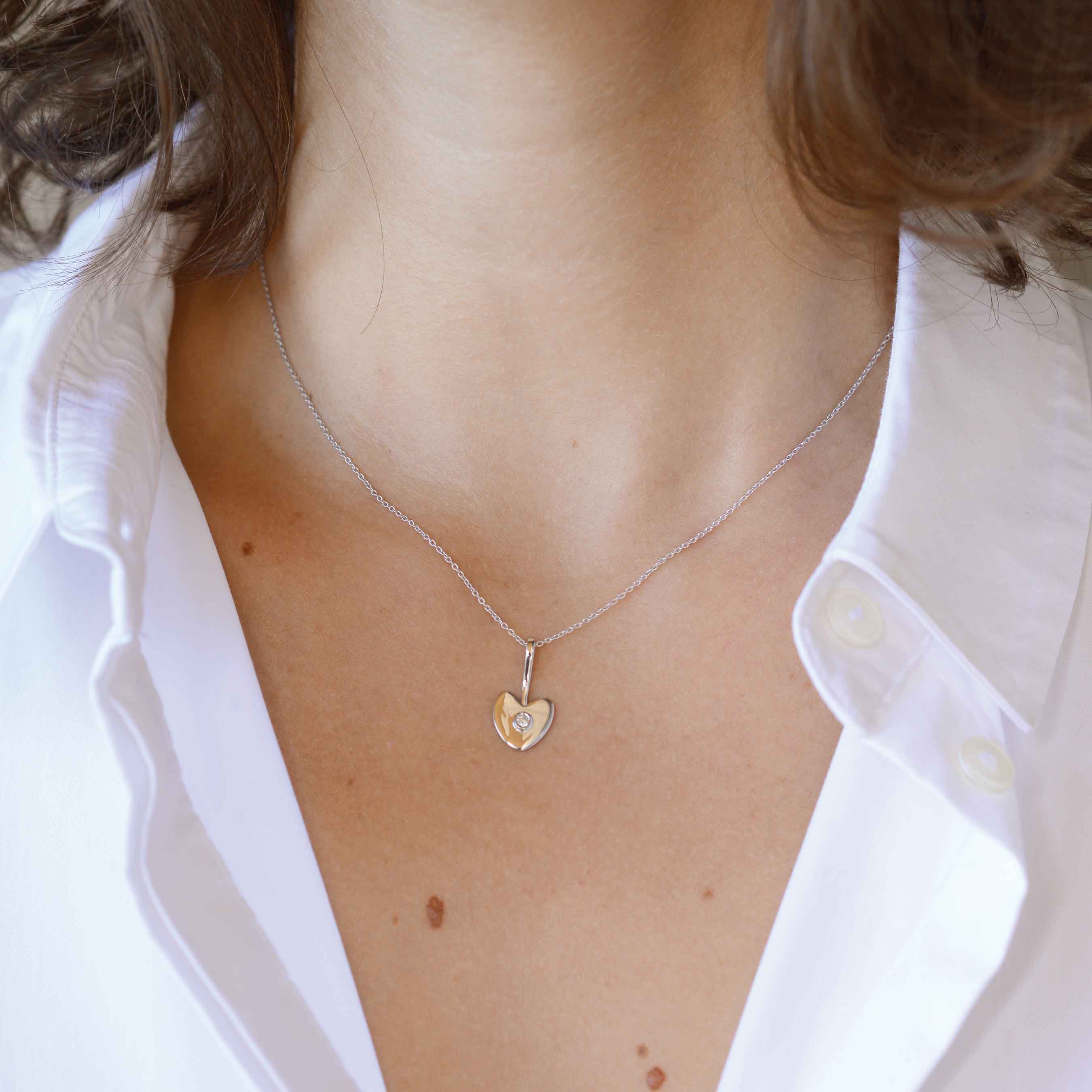 heart gold necklace with white diamondon a woman