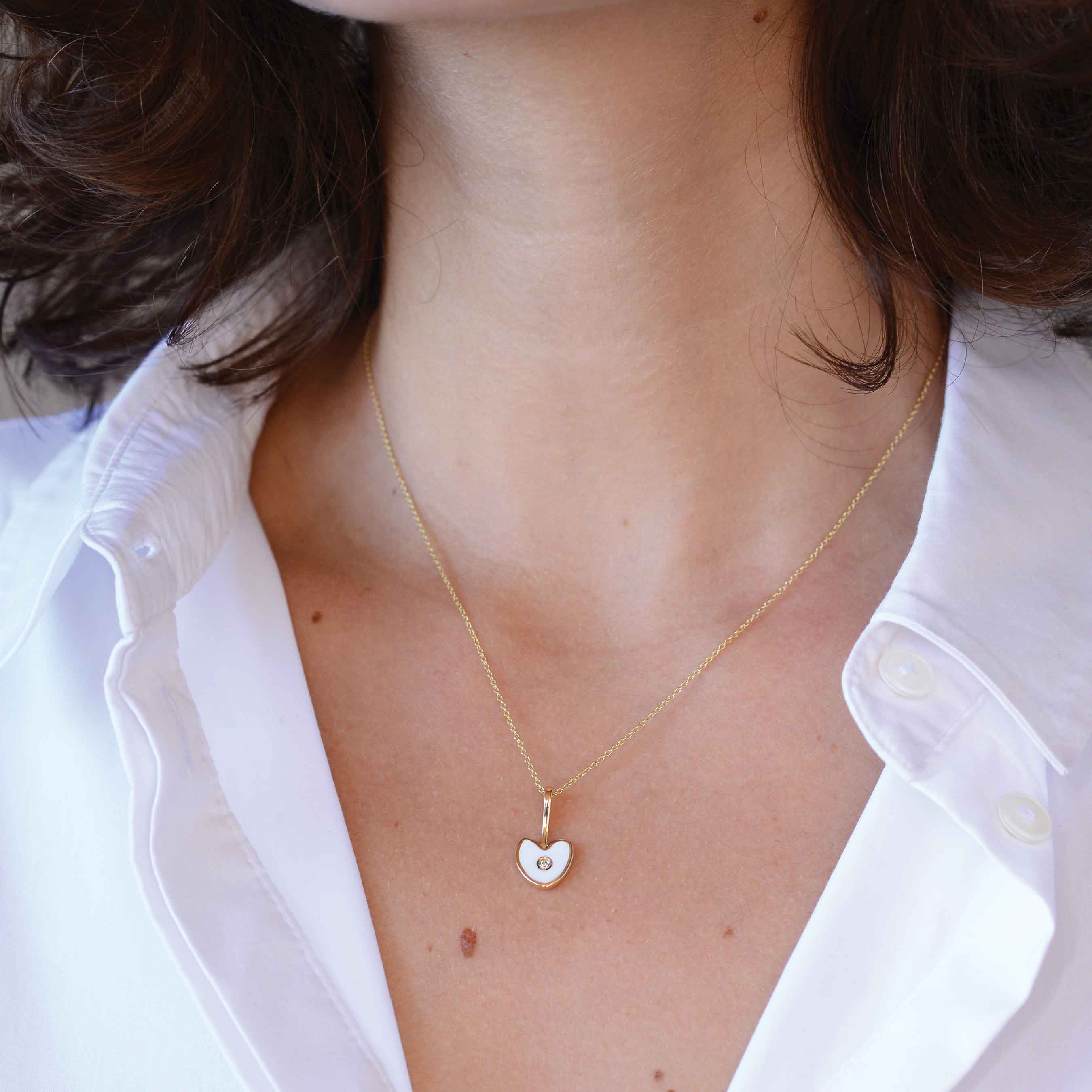 white gold heart with white diamond on a woman