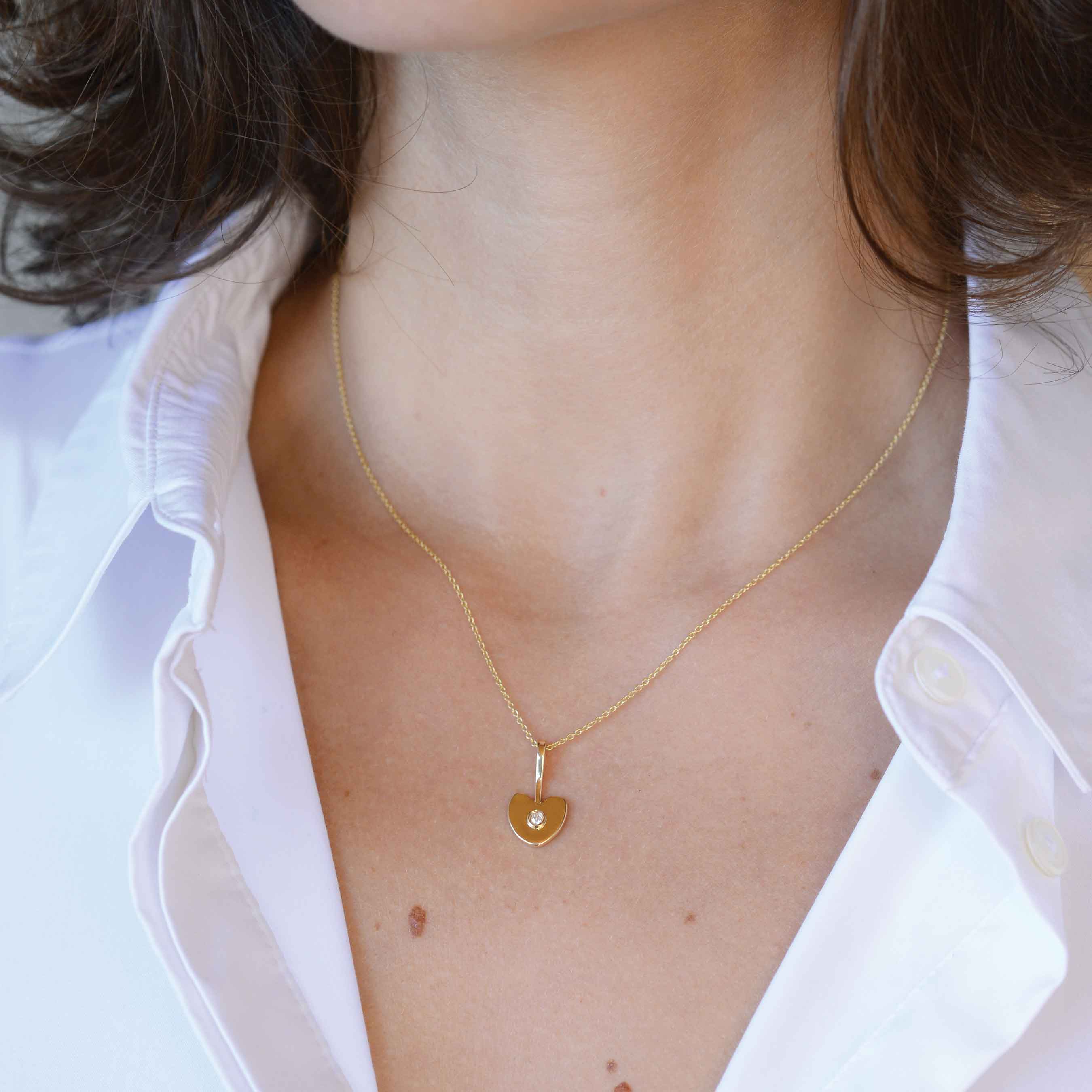 yellow gold heart with white diamond on a woman