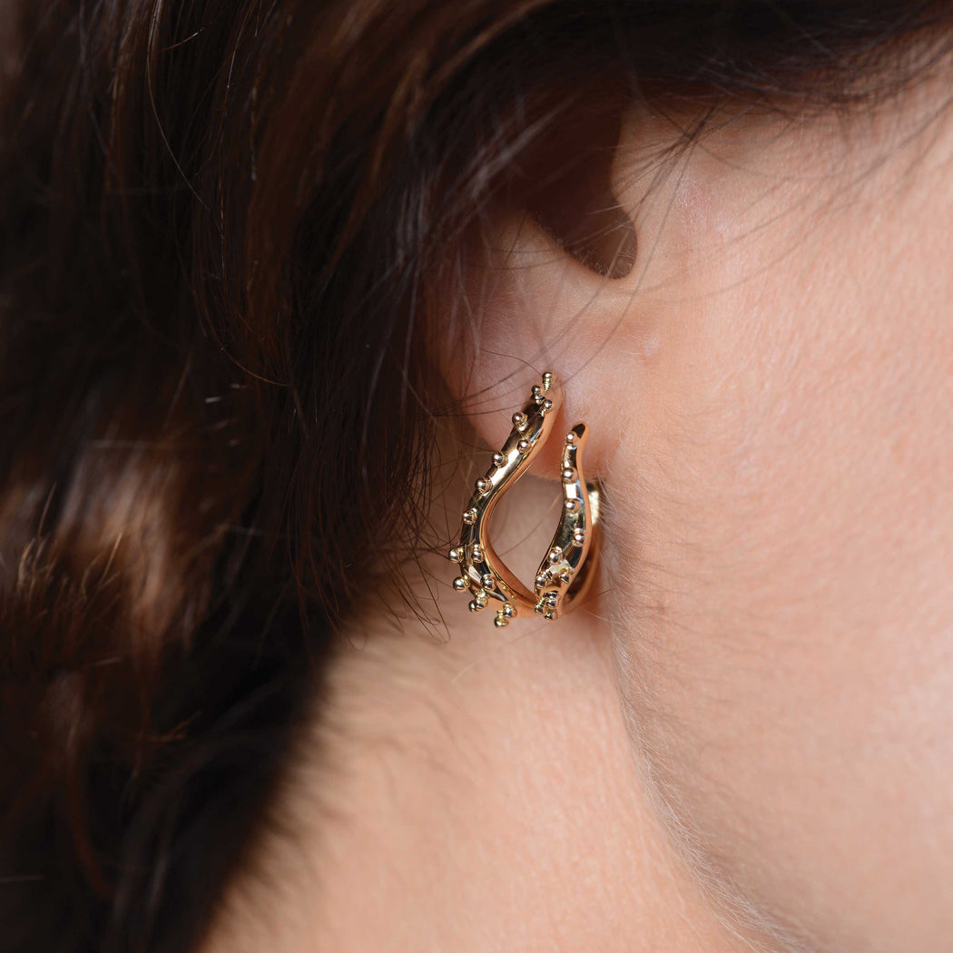 yellow gold earrings on a woman