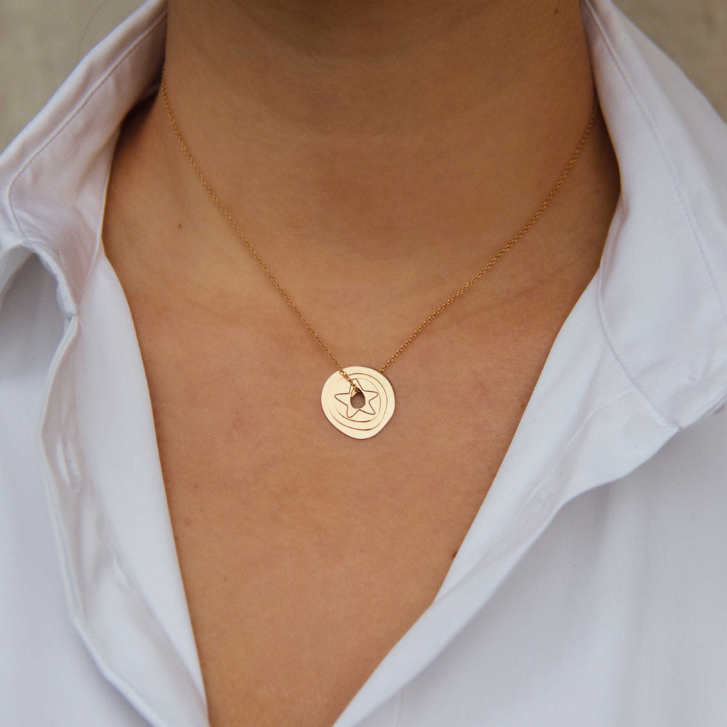 rose gold pendant with a star on a woman